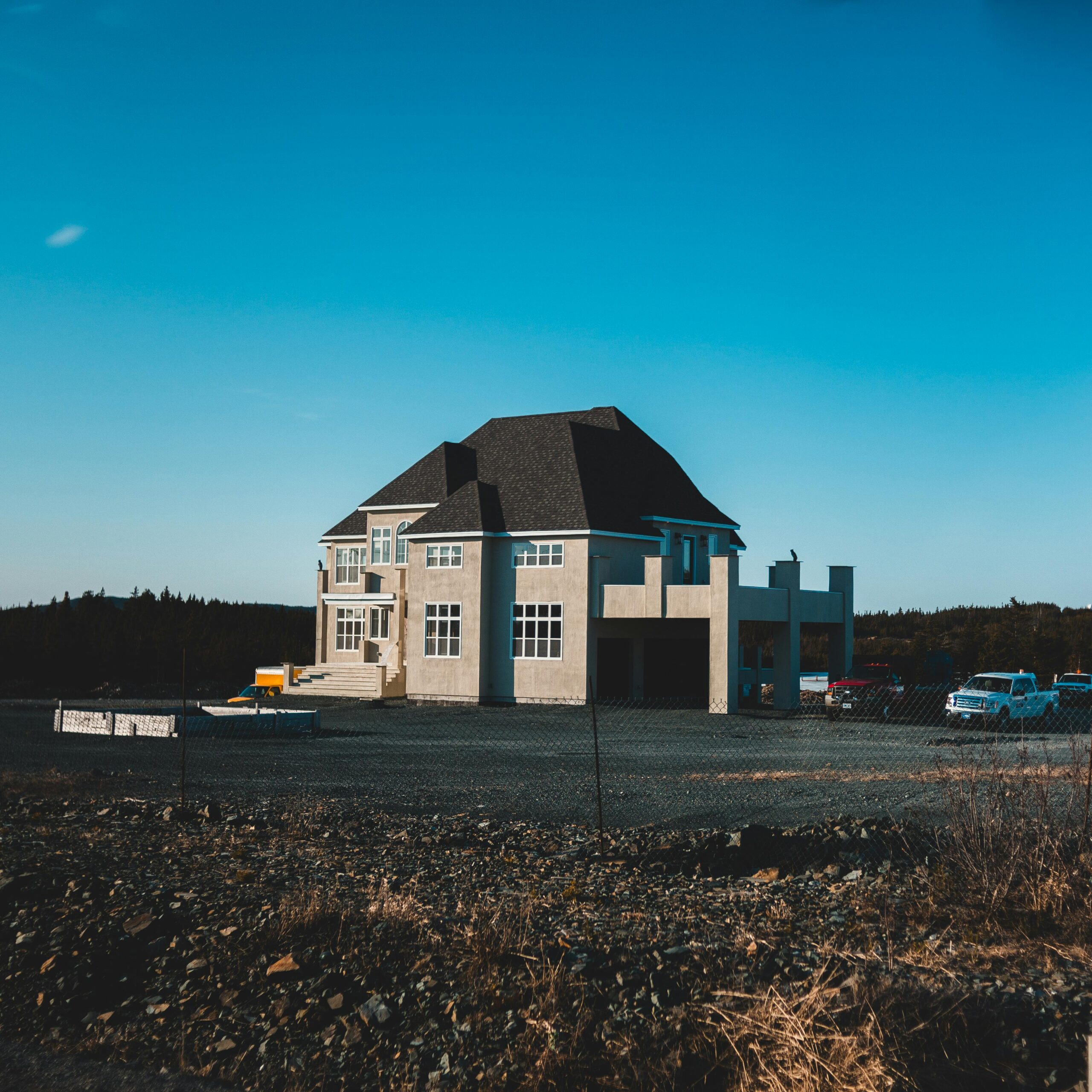 A modern house in a tranquil setting with blue skies and surrounding nature.