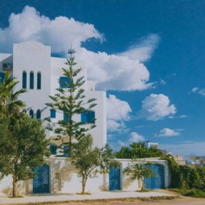 A beautiful Mediterranean building with white walls and blue accents set against a clear sky.